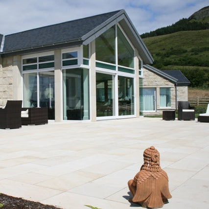 Modern stone bungalow with Mountcharles Sandstone Paving Slabs in patio area. 