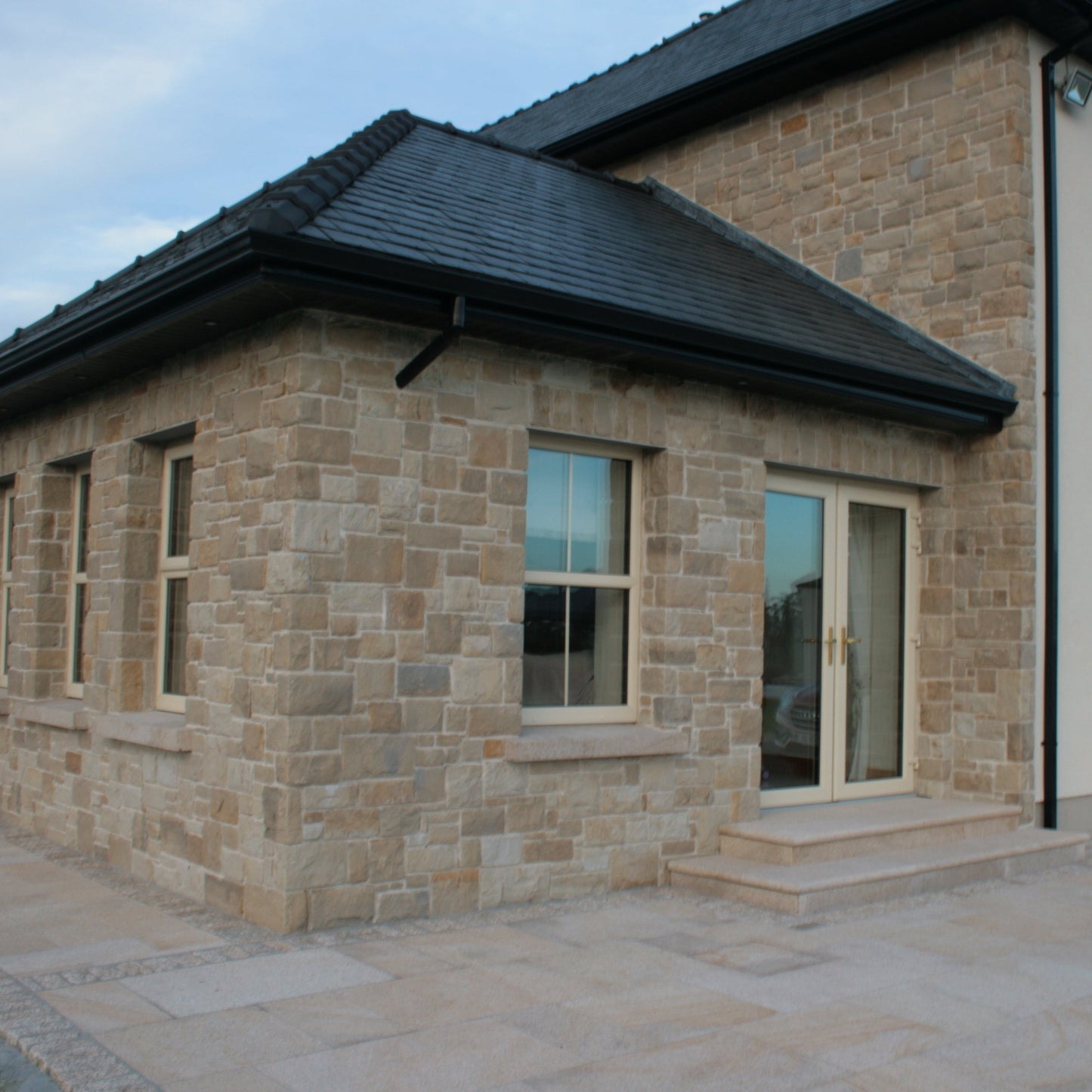 Mountcharles Sandstone Stoneer Cladding installed on a sunroom and wall façade. 