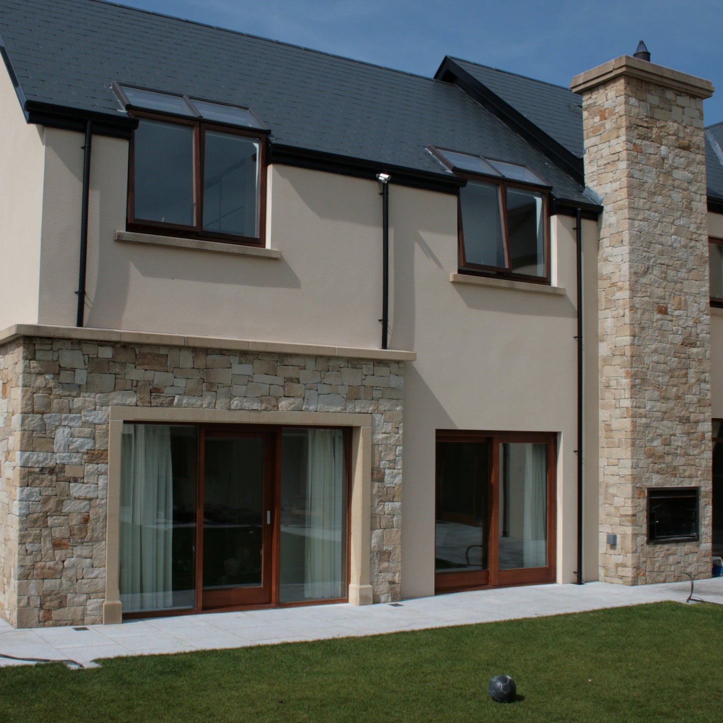 Modern house with outdoor fireplace cladded in Mountcharles Sandstone Stoneer Cladding. 