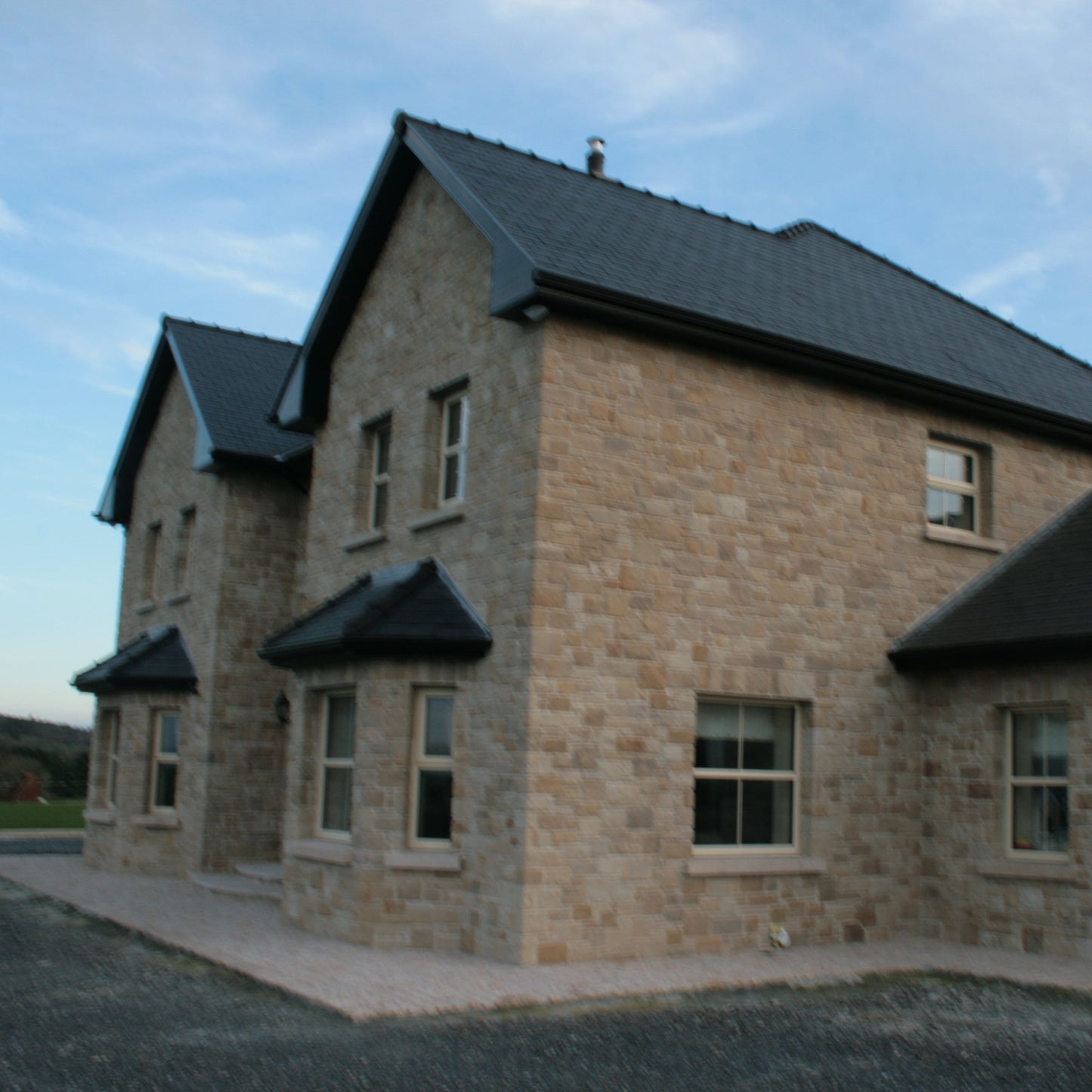 Large stone house finished with Mountcharles Sandstone Stoneer Cladding. 
