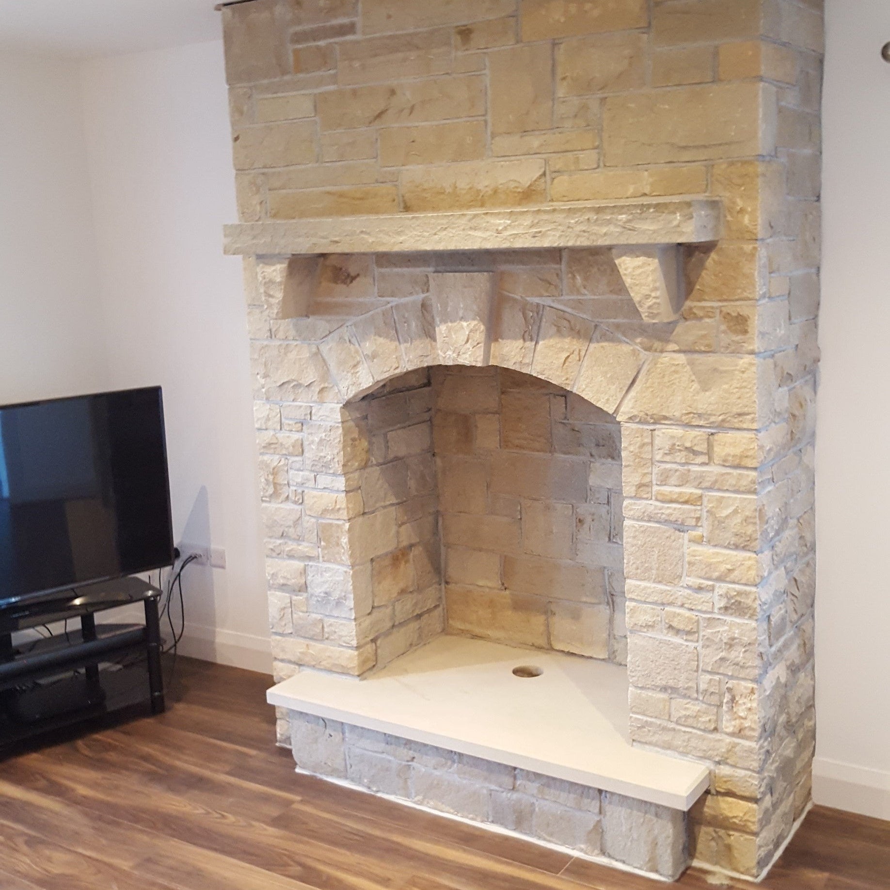 Stone fireplace completed using Mountcharles Sandstone Stoneer Cladding and bespoke sandstone hearth and mantel. 