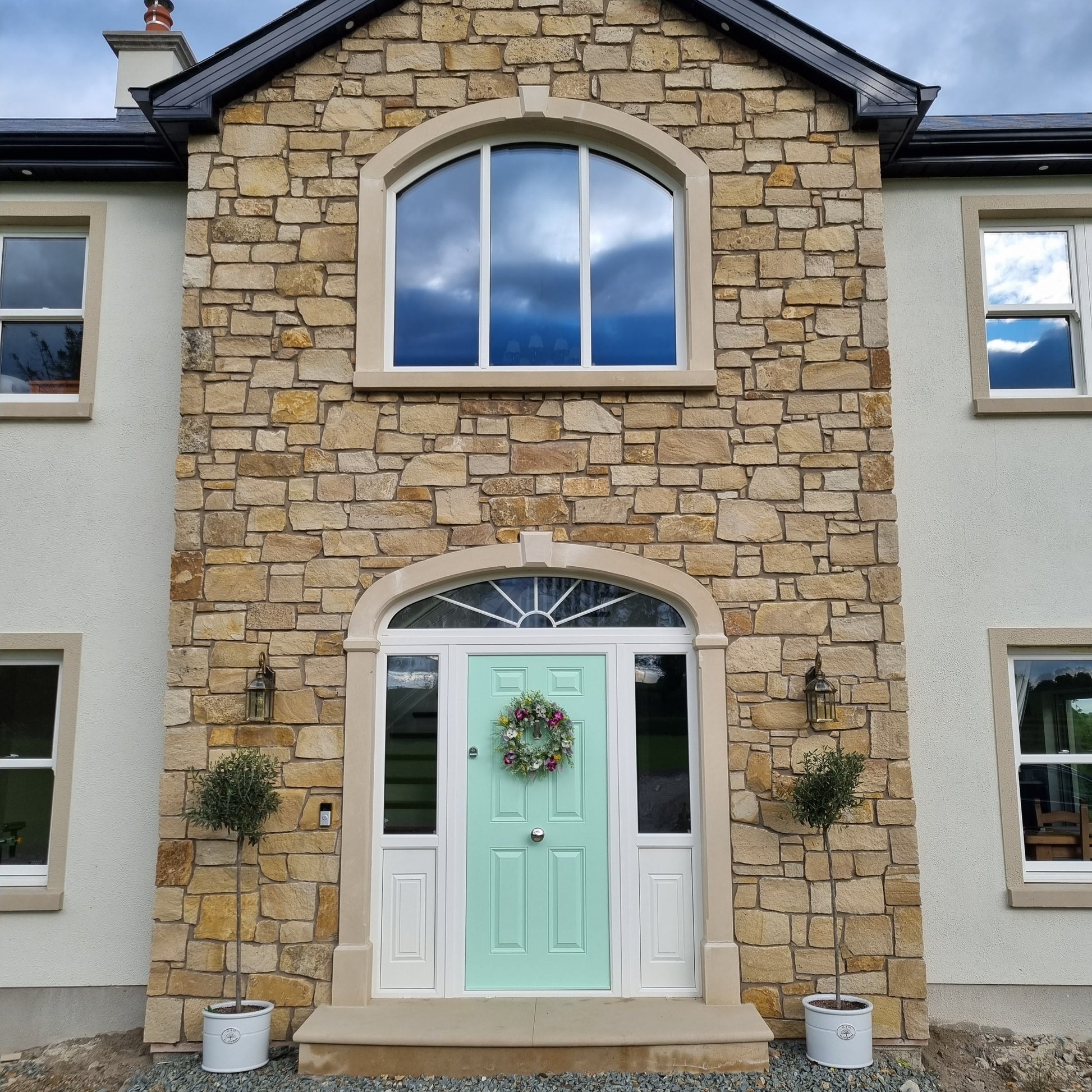 External stone feature wall in Mountcharles Sandstone Stoneer Cladding and bespoke Mountcharles Sandstone Surrounds. 