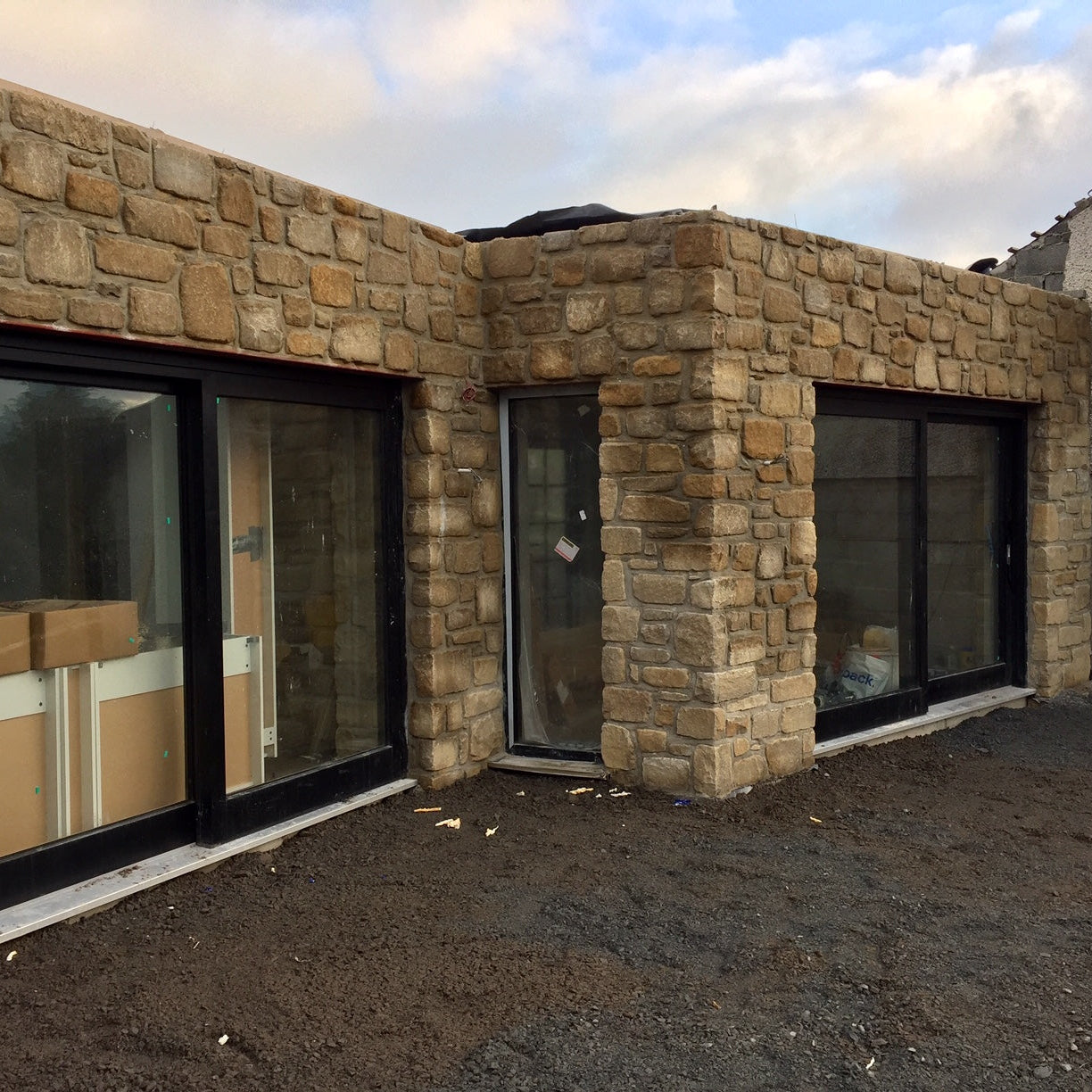 Stone building in Mountcharles Sandstone with large windows under a cloudy sky