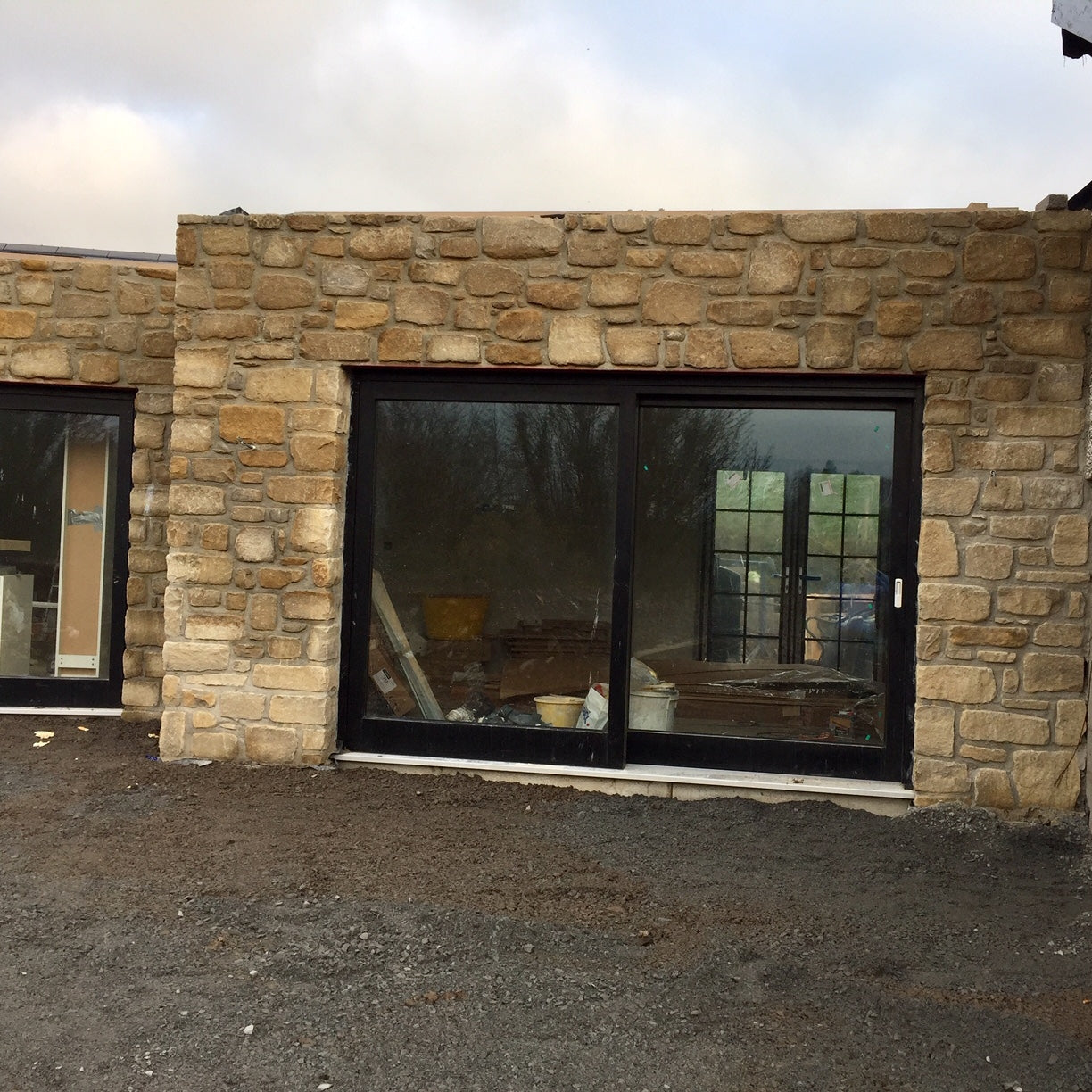 Stone wall in Mountcharles Sandstone tumbled stone with large glass doors. 