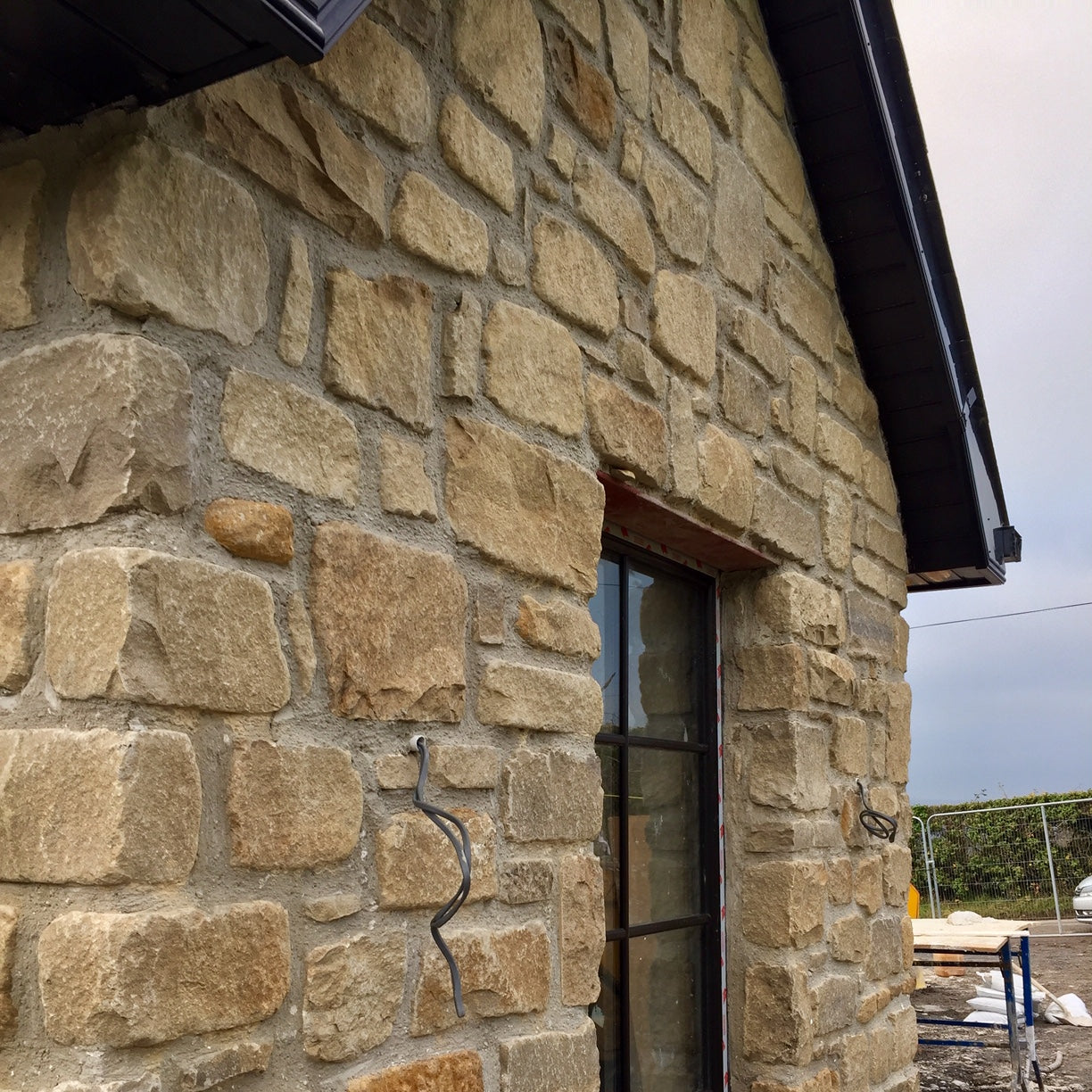 Stone wall in Mountcharles Sandstone Tumbled with a window and outdoor view