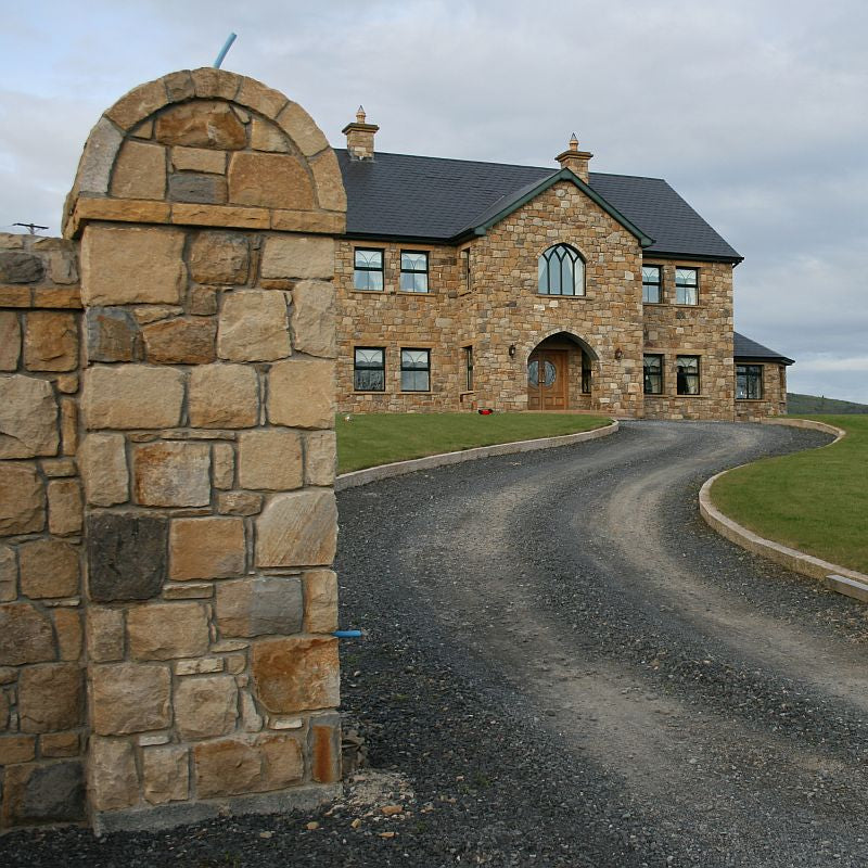 Two storey stone house with entrance pillar and walls completed in Mountcharles Sandstone Machined Rubble