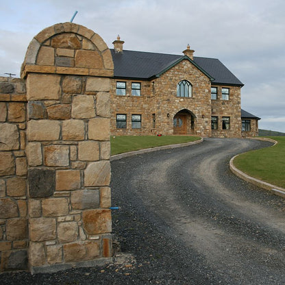 Two storey stone house with entrance pillar and walls completed in Mountcharles Sandstone Machined Rubble