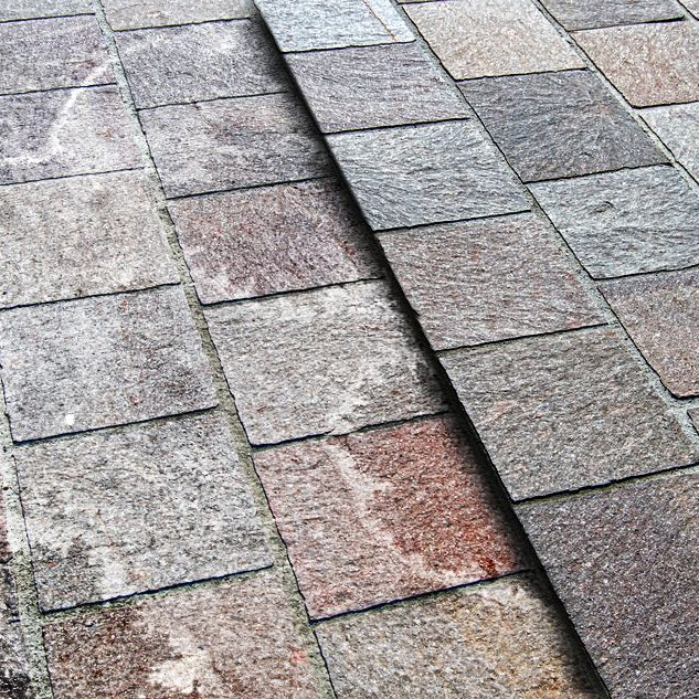 Image of paving with white efflorescence staining on one side and other side clean.