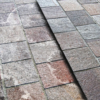 Image of paving with white efflorescence staining on one side and other side clean.