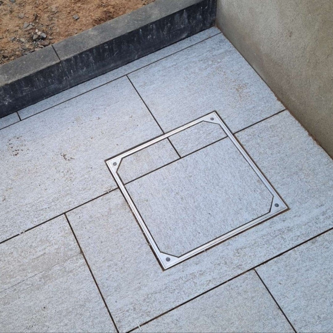 Pathway featuring recessed manhole cover installed using Pietra Di Bagnolo Porcelain Tiles. 