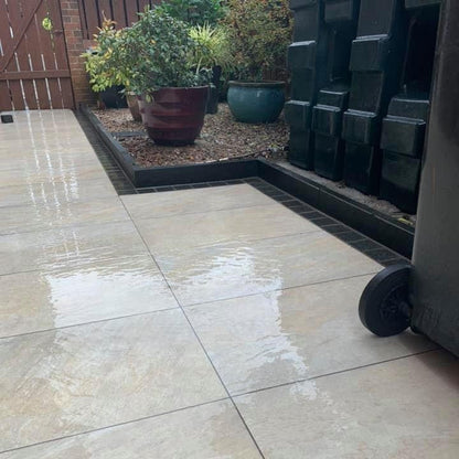 Close up detail of patio area featuring Pietra Di Barge porcelain tiles photographed wet. 