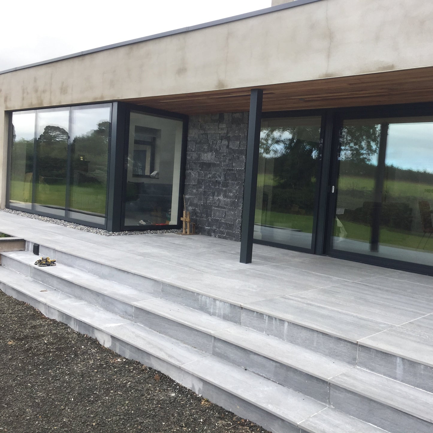 Modern house with patio area and steps completed using Pietra Di Vals porcelain paving tiles. 