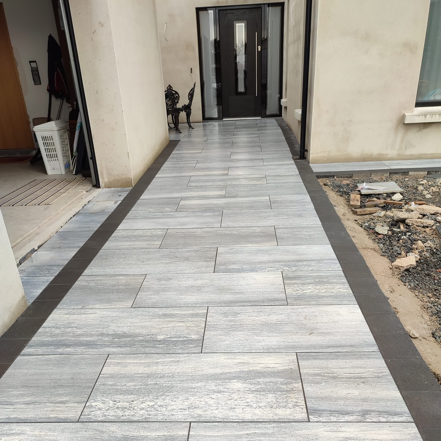 Porcelain Pathway leading past garage door to front entrance. Paving is Pietra di Vals porcelain tiles