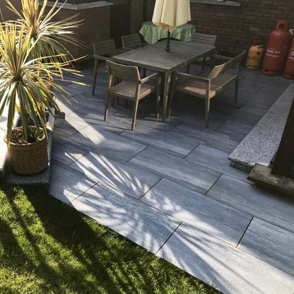 Small Patio area with garden furniture and potted plants. Paving is Pietra di Vals porcelain tiles.