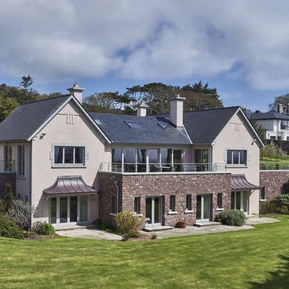 Large modern house with natural stone feature wall in Pink Sandstone Machined building stone. 