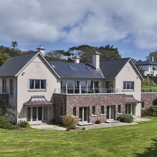 Large modern house with natural stone feature wall in Pink Sandstone Machined building stone. 