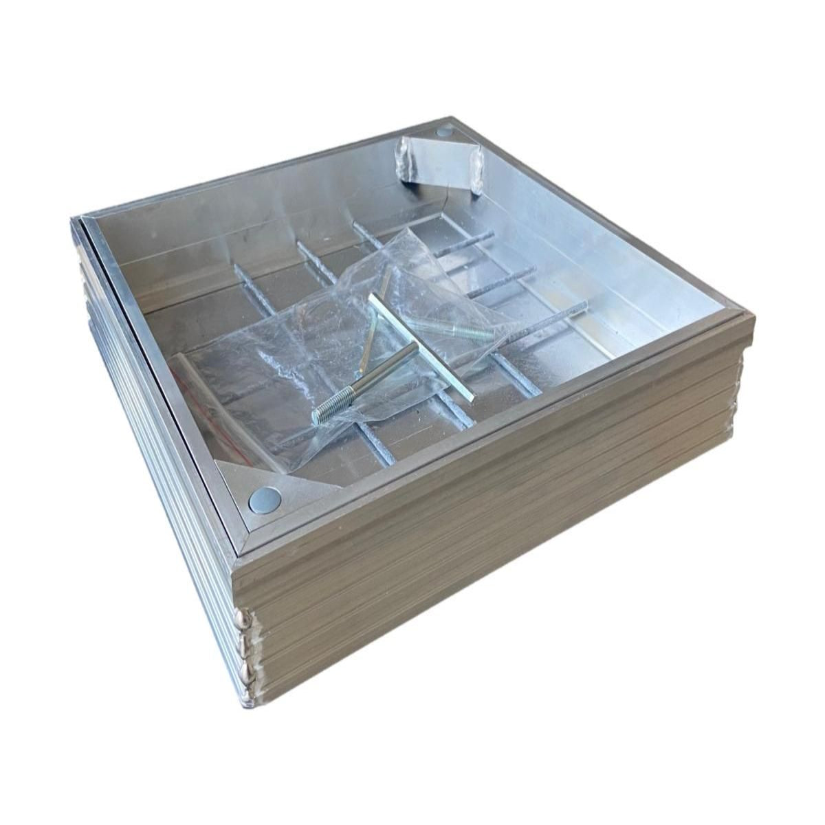 A recessed manhole cover with a metal frame and a clear plastic wrapping on top, designed to fit into a 300 x 300 mm space.