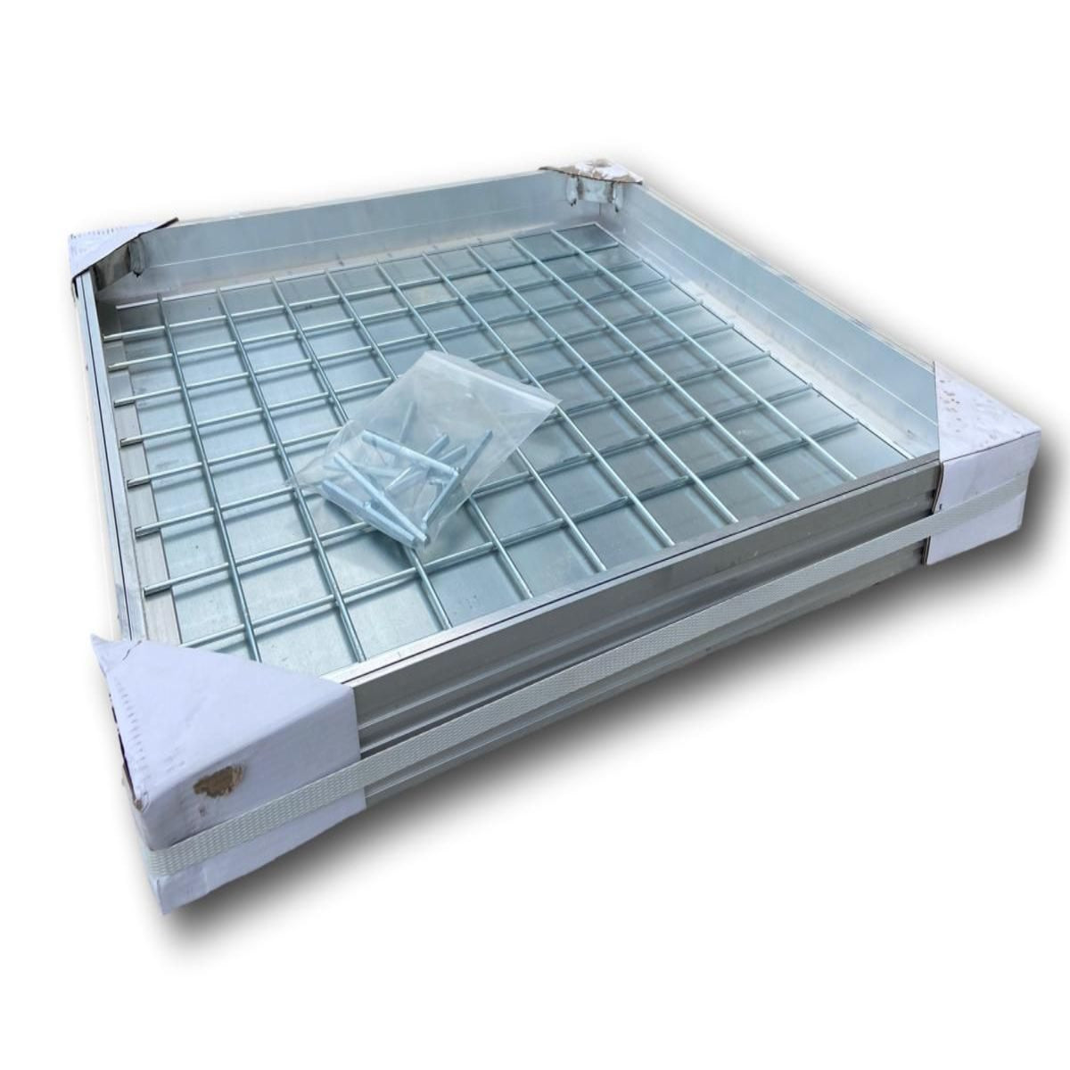 A recessed metal manhole cover with a grid design and a removable section in the center, designed to be laid within a surrounding area like paving or bricks.