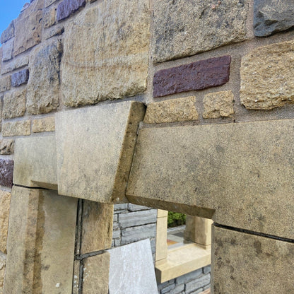 Close-up of a stone wall with bespoke sandstone lintel and keystone detail. 