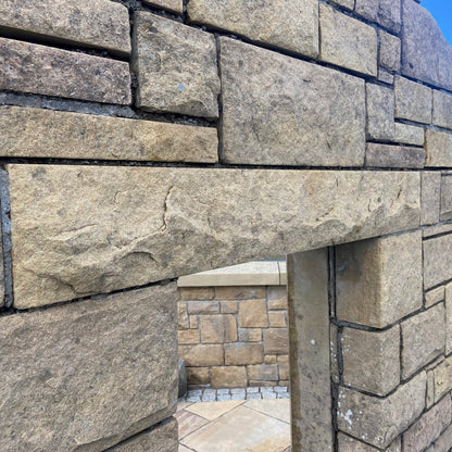 Stone display wall with bespoke sandstone lintel with a rockfaced finish. 