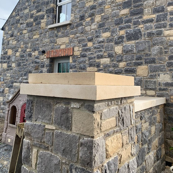Stone house with bespoke sandstone pillar and wall capping. 
