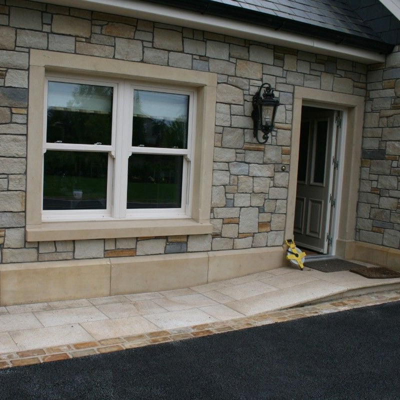 Stone house with bespoke sandstone window and door surround with bespoke sandstone plinths.  