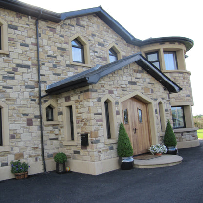 Stylish house with stone façade and decorative elements including bespoke sandstone plinths