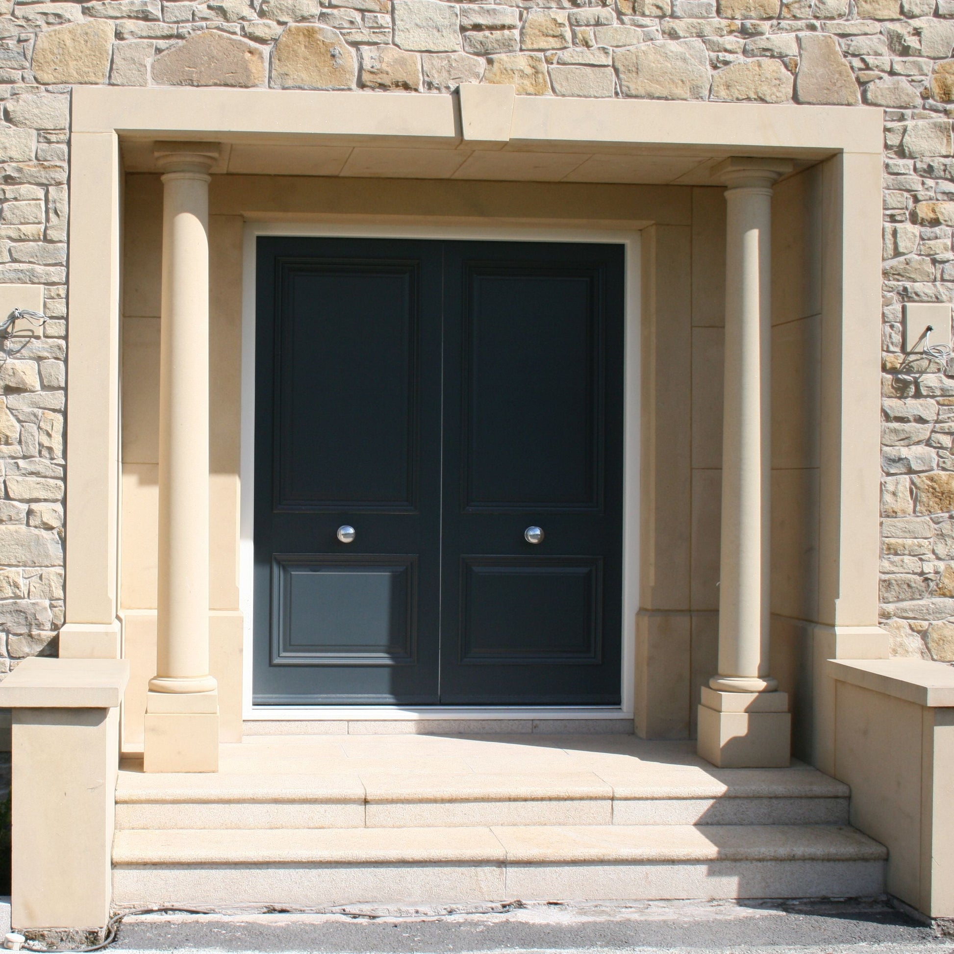 Contemporary sandstone portico on a natural stone house. 