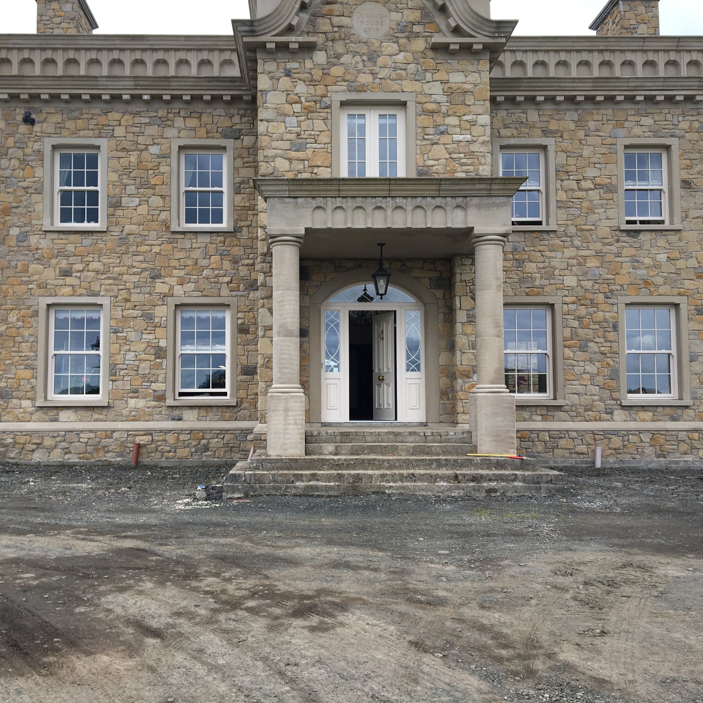 Large stone mansion with sandstone portico.  