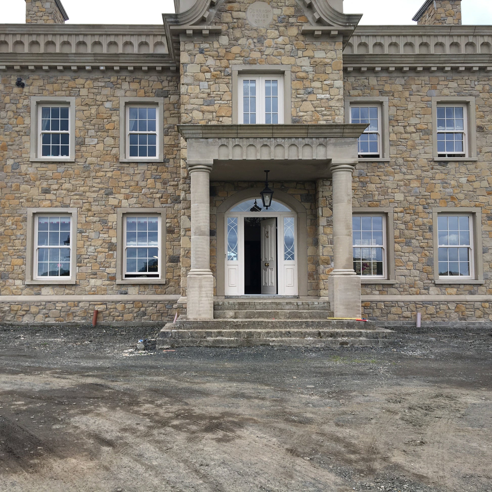 Large stone mansion with sandstone portico.  