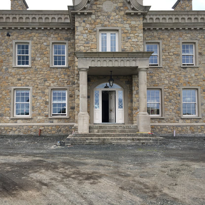 Large stone mansion with sandstone portico.  