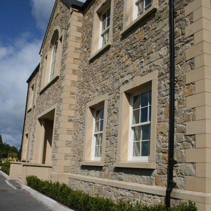Close up of bespoke sandstone quoins, window surrounds and string course. 