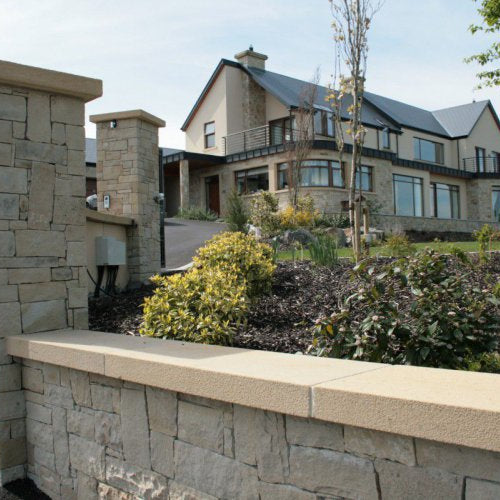 Low boundary wall with high pillars completed using bespoke sandstone wall capping. 