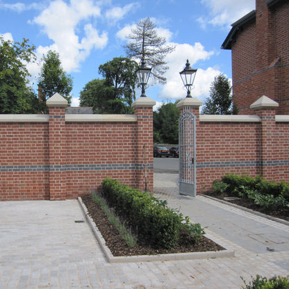 Brick wall with bespoke sandstone wall and pillar capping.