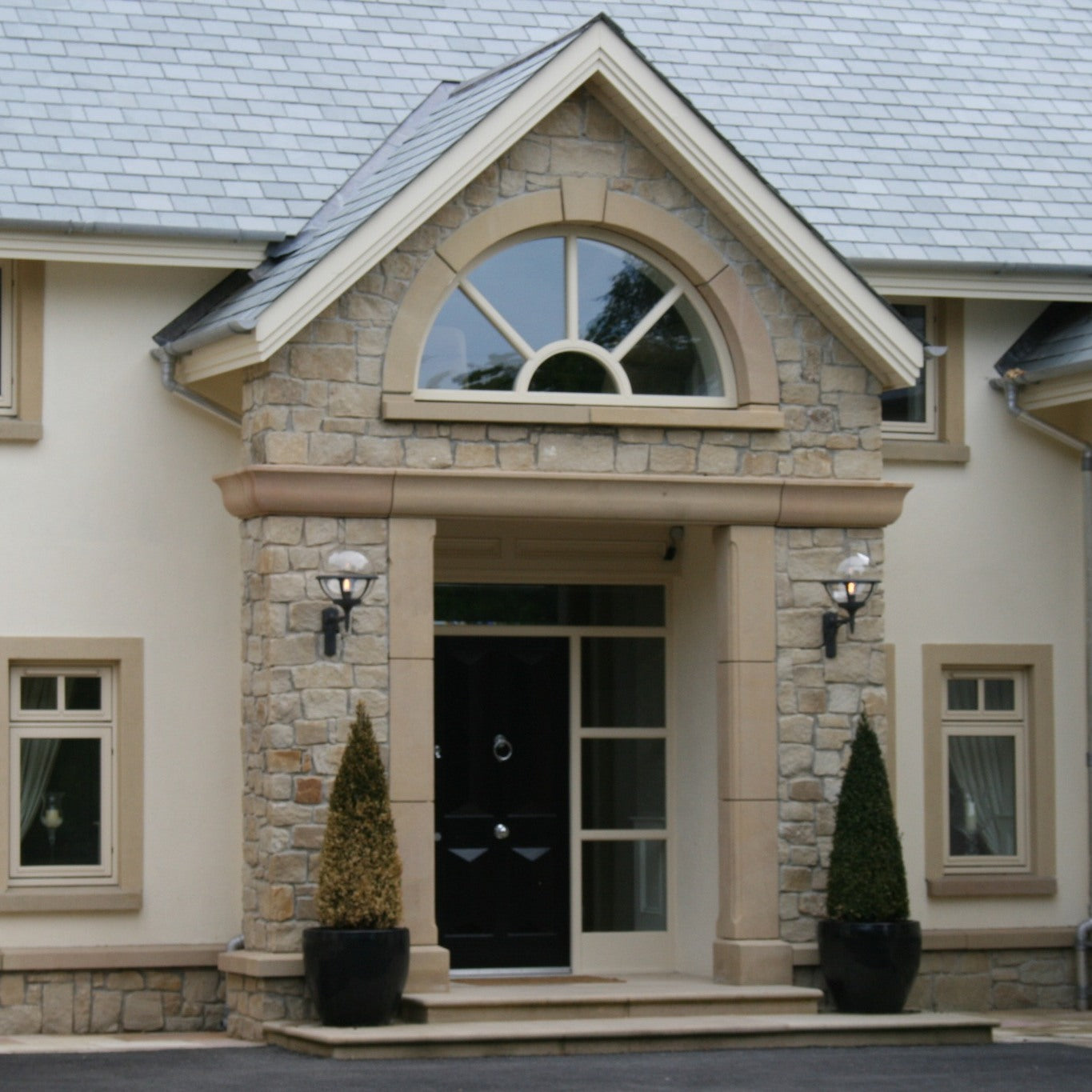 Stone entrance with bespoke semi circle window surrounds. 
