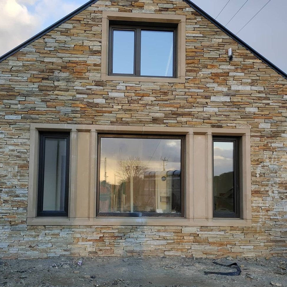 Stone gable with bespoke sandstone window surrounds. 