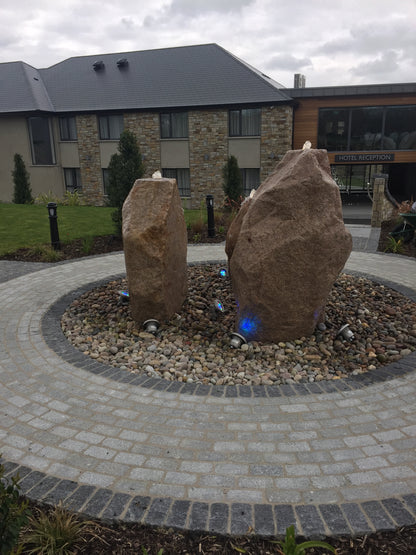 Garden feature showcasing three large sandstone monoliths on top of Scottish Beach Pebbles. 