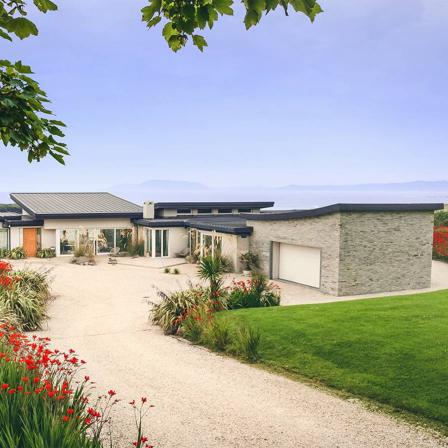 Contemporary home with a stone feature wall in Silver Donegal Quartzite Garden Walling.