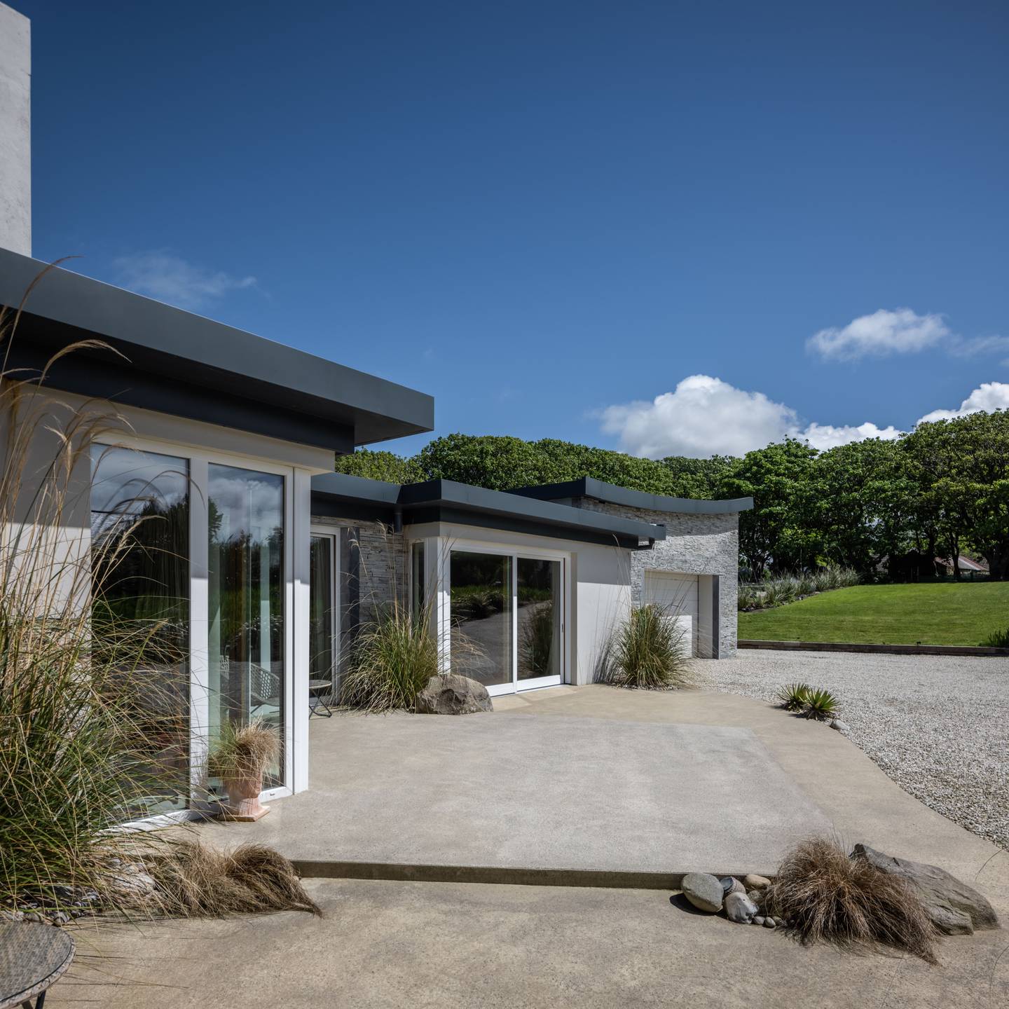 Contemporary house with natural stone feature walls in Silver Donegal Quartzite Garden Walling.