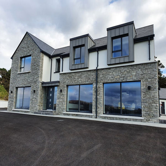 A modern house featuring Silver Donegal Quartzite machined stone blocks on its facade.