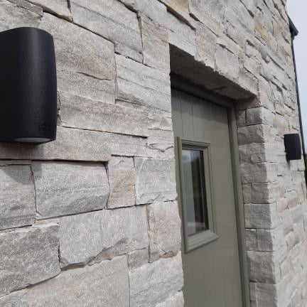 Close up of front door and surrounding stonework in Silver Donegal Quartzite Stoneer Cladding. 
