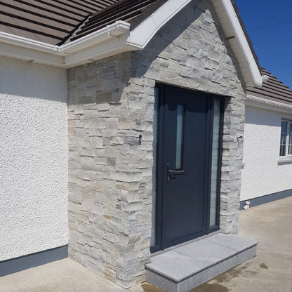 Stone porch with grey door completed in Silver Donegal Quartzite Stoneer Cladding. 