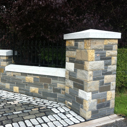 Stone wall with bespoke silver granite apex pillar cap and wall capping. 