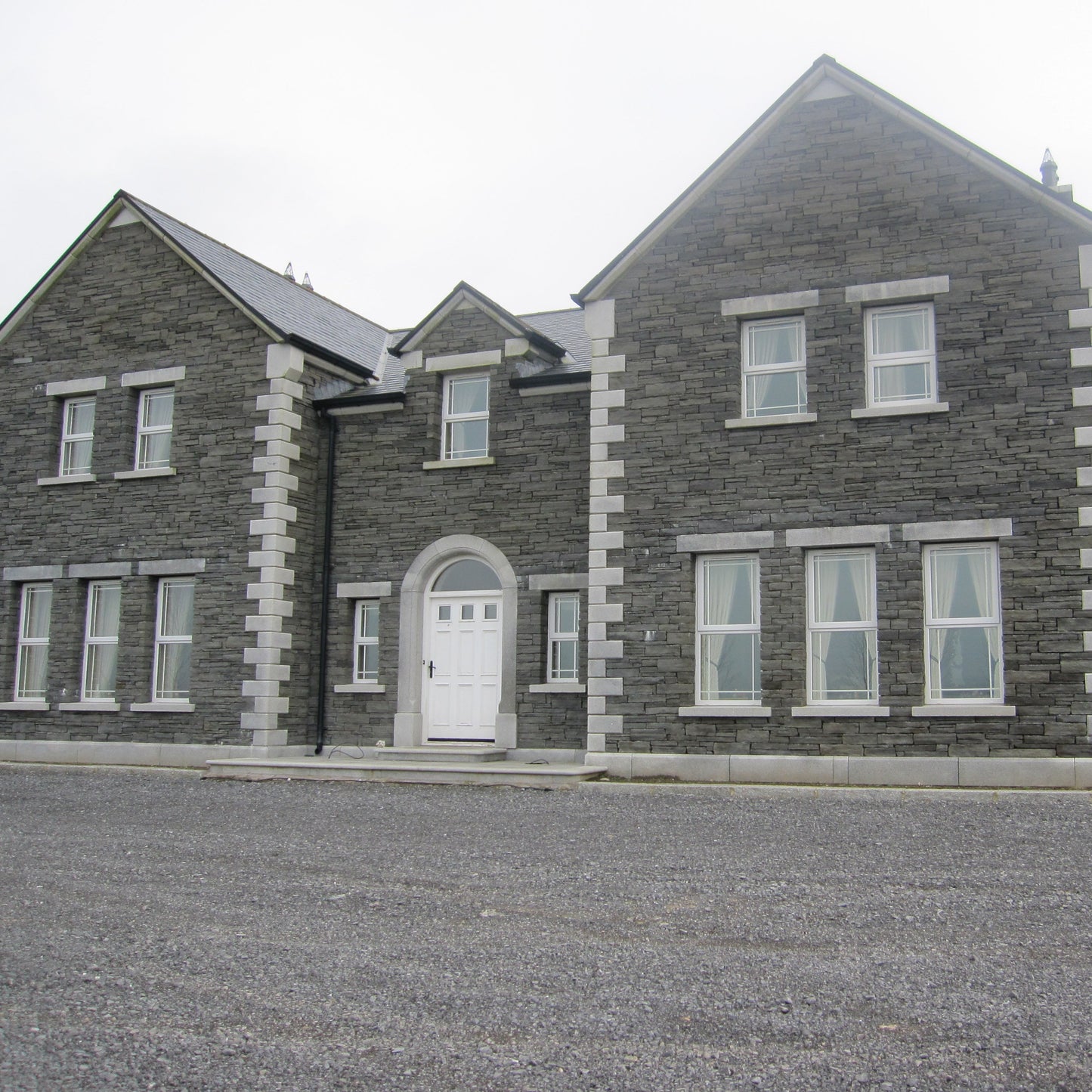 Large stone house with bespoke silver granite door surround and lintels and sills.