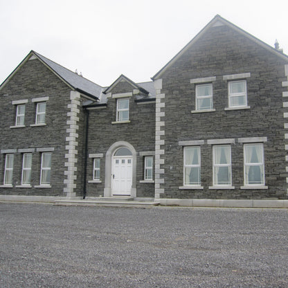 Large stone house with bespoke silver granite door surround and lintels and sills.