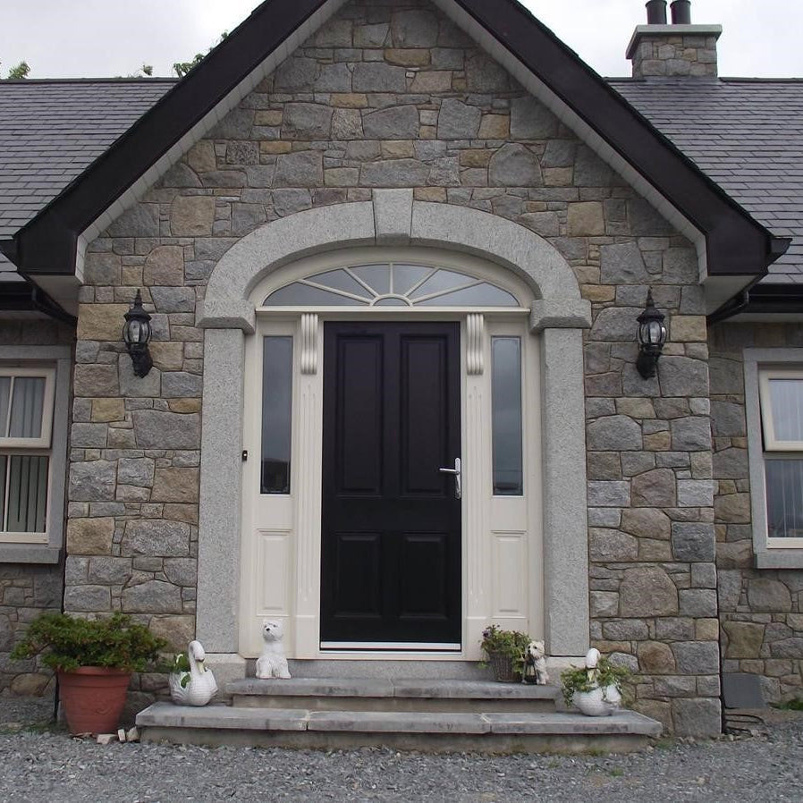 Stone house with a black door featuring a Silver Granite Door Surround.