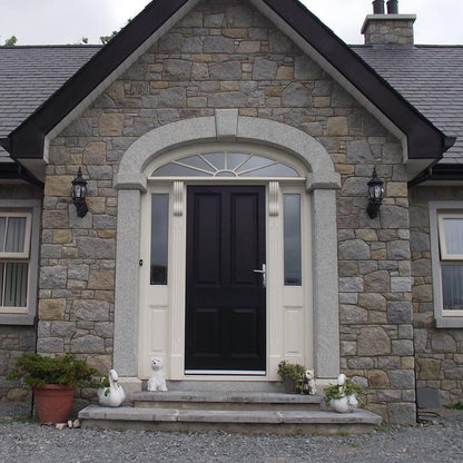 Stone house with a black door featuring a Silver Granite Door Surround.