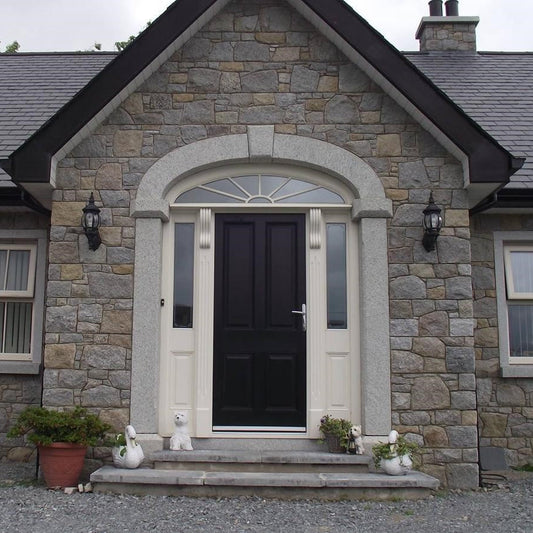 Stone house with a black door featuring a Silver Granite Door Surround.