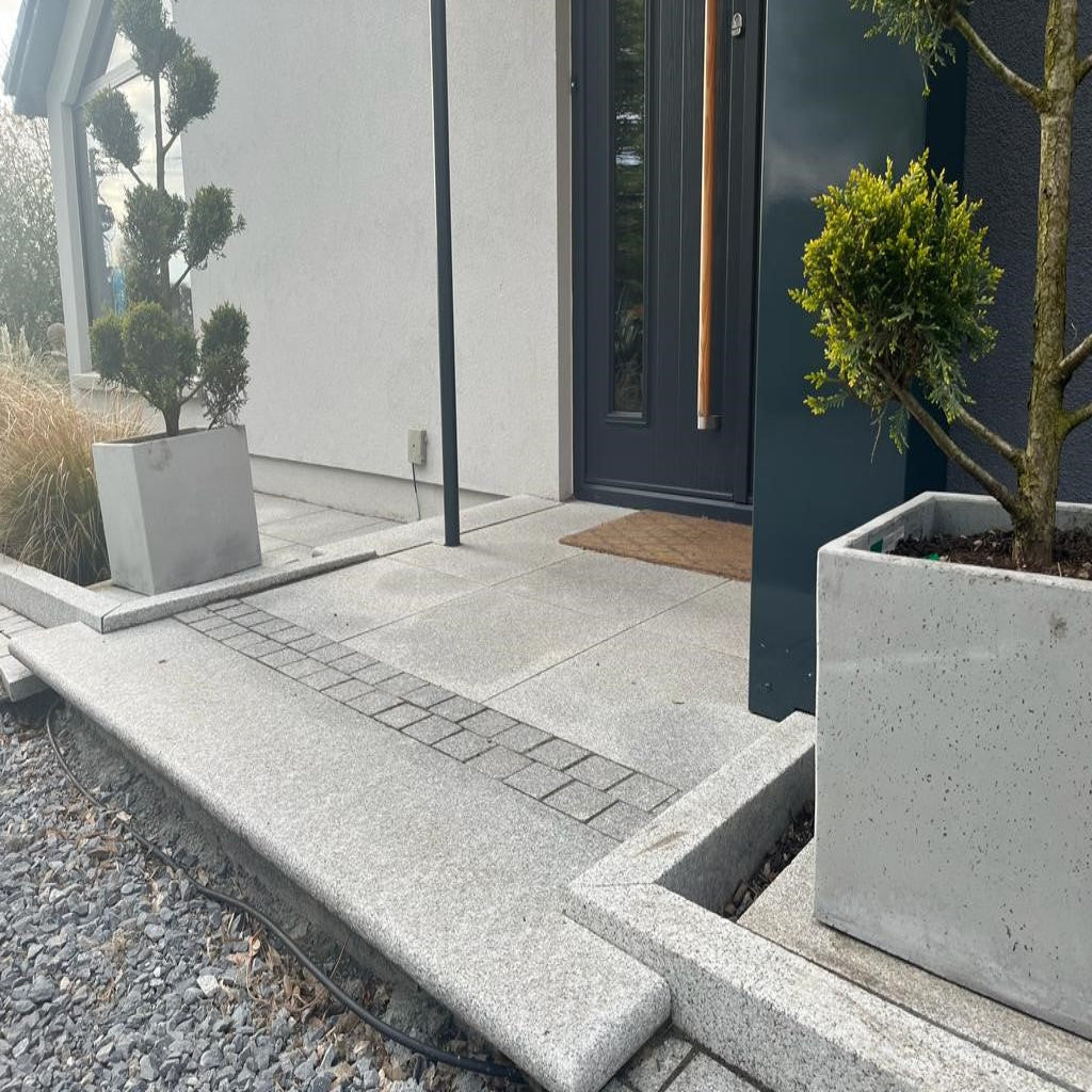 Modern front door step surrounded by Silver Granite Kerbing with a blasted finish.  