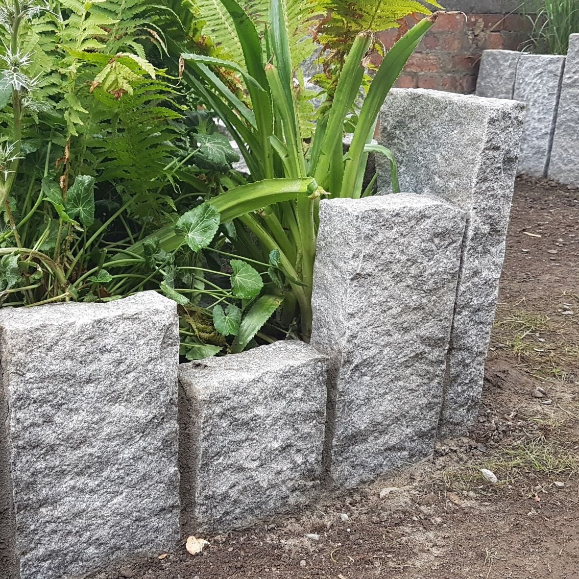 Planting beds surrounded by Silver Granite Kerbs with a pineapple finish. 